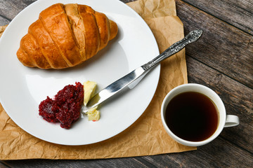 breakfast with croissant. the beginning of the morning. Fresh french croissant. Coffee cup and fresh baked croissants on a wooden background. View from above. Morning breakfast with croissant and coff
