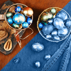 Painted colored Easter eggs in golden bowl and copper mug on red animal skin. Boho stile. Coloring page for the color of 2020.