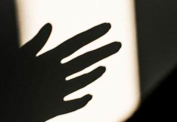  Shadow of a hand on a white background.