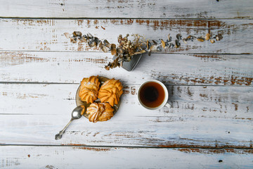 cup of coffee and creamy dough. Cup of coffee and pastry composition. Cup of coffee and sweet pastry with cream filling on a light background