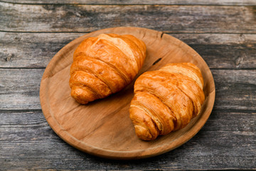 two croissants. Fresh french croissant. on a wooden background. View from above. Morning breakfast with a croissant. French breakfast. Great homey. Fresh tower.