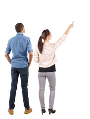 Obraz premium Back view of a stylish couple pointing.