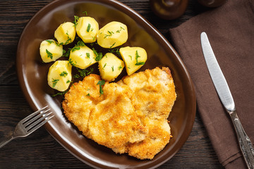 Chop pork cutlets , served with boiled potatoes and tzatziki dip. 