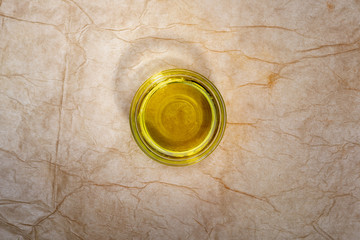 Extra virgin olive oil in glass bowl. Rustic Background. Top view.