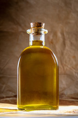 Extra virgin olive oil in glass bottle. Rustic Background. Front view.