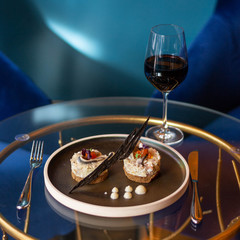 Glass of red wine with fish starter and brawn bread on a glass table