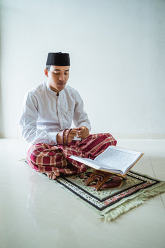 muslim male reading qoran and praying. islam asian man