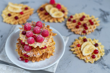 Traditional Belgian waffles with fresh fruits, sprinkled with powdered sugar and cocoa. You can eat for breakfast with compote or coffee. Holiday breakfast. Copy space.  