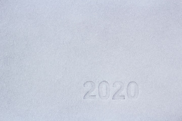 Prints of the numbers two thousand and twenty in the snow, as a symbol of the coming new year.