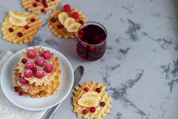 Traditional Belgian waffles with fresh fruits, sprinkled with powdered sugar and cocoa. You can eat for breakfast with compote or coffee. Holiday breakfast. Copy space.  