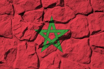 Morocco flag depicted in paint colors on old stone wall closeup. Textured banner on rock wall...