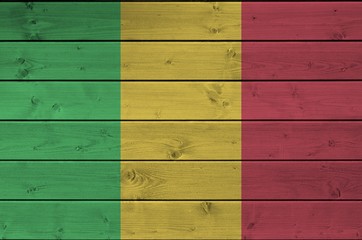 Mali flag depicted in bright paint colors on old wooden wall. Textured banner on rough background