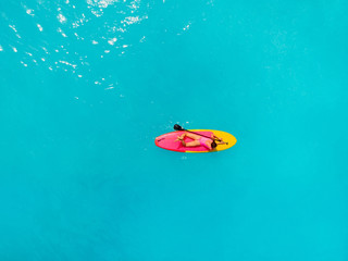 Attractive woman relax on stand up paddle board in blue ocean. Sup surfing in tropical sea