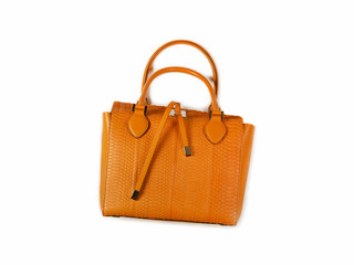 Yellow women bag made of python skin with handles lies on its side top view