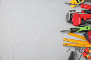 Flat lay composition with construction tools on light grey background. Space for text