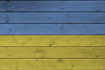 Ukraine flag depicted in bright paint colors on old wooden wall. Textured banner on rough background