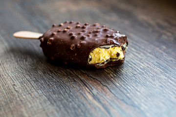 Bitten ice cream popsicle covered with chocolate