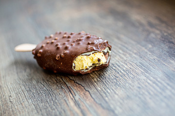 Bitten ice cream popsicle covered with chocolate
