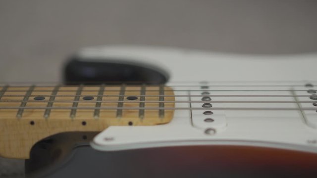 Soft footage in close up of electric guitar  on the carpet.