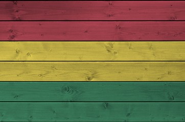 Bolivia flag depicted in bright paint colors on old wooden wall. Textured banner on rough background