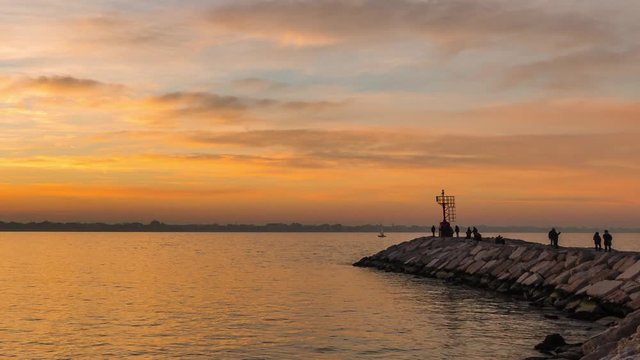 Sunset at Rimini port with a passing boat 