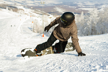Active man snowboarder riding on slope. Snowboarding closeup.