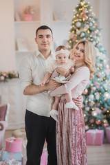 family portrait in christmas decorated interior near new year tree