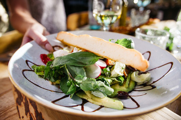 Top view of a delicious sunny Italian lunch with salad and bread on a decorated table