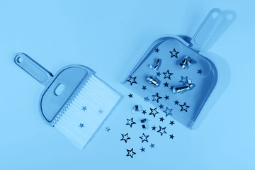 Blue broom and dustpan on pastel pink background. Main color trend for 2020 year.