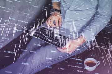 Forex graph with businessman working on computer in office on background. Concept of analysis....