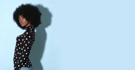 Afro-american model in original black golf with white dots isolated on blue background. - obrazy, fototapety, plakaty
