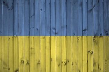 Ukraine flag depicted in bright paint colors on old wooden wall. Textured banner on rough background