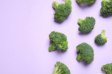 Fresh tasty broccoli on violet background, flat lay. Space for text