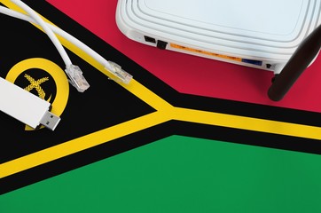 Vanuatu flag depicted on table with internet rj45 cable, wireless usb wifi adapter and router....