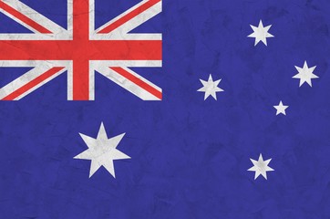 Australia flag depicted in bright paint colors on old relief plastering wall. Textured banner on...