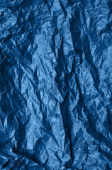 Photo of crumpled paper texture in trendy blue color.