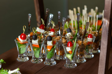 A table with catering cups with teaspoons..