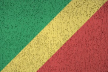 Congo flag depicted in bright paint colors on old relief plastering wall. Textured banner on rough...