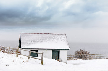 Little house by the ocean on a winter snowy day. Portland USA. Maine