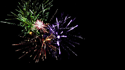 Colorful traditional fireworks in dark night sky, isolated on black