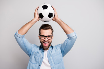 Photo of crazy handsome guy raising white black soccer ball above head yell support team football...