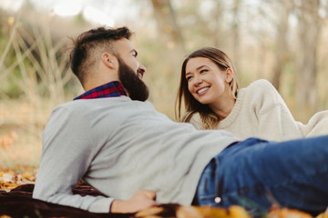 Young happy couple enjoying in autumn day and talking to each other