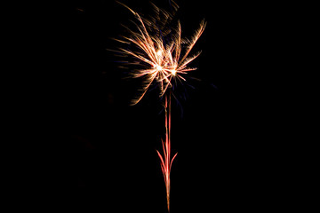 Orange festive firework on party, isolated on black