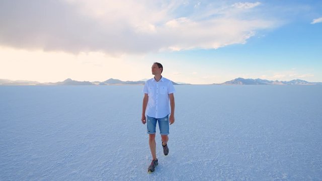 Bonneville Salt Flats near Salt Lake City, Utah with handheld pov panning of man walking on white field in summer