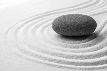 Fototapeta premium Szary kamień na piasku z wzorem. Zen, medytacja, harmonia