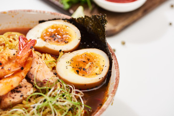 close up view of spicy seafood ramen with shrimps in bowl