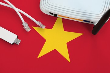 Vietnam flag depicted on table with internet rj45 cable, wireless usb wifi adapter and router....