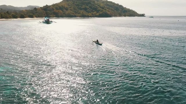 paying left with a drone and following a bangka boat with people in it