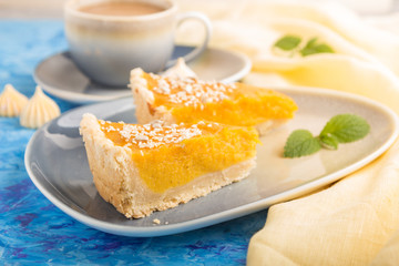 Two pieces of traditional american pumpkin pie with cup of coffee on a blue concrete background. side view, selective focus.