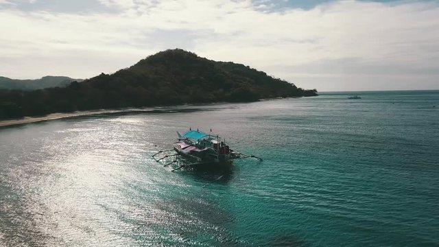 circling around  a bangka boat with a sun  reflection in the water